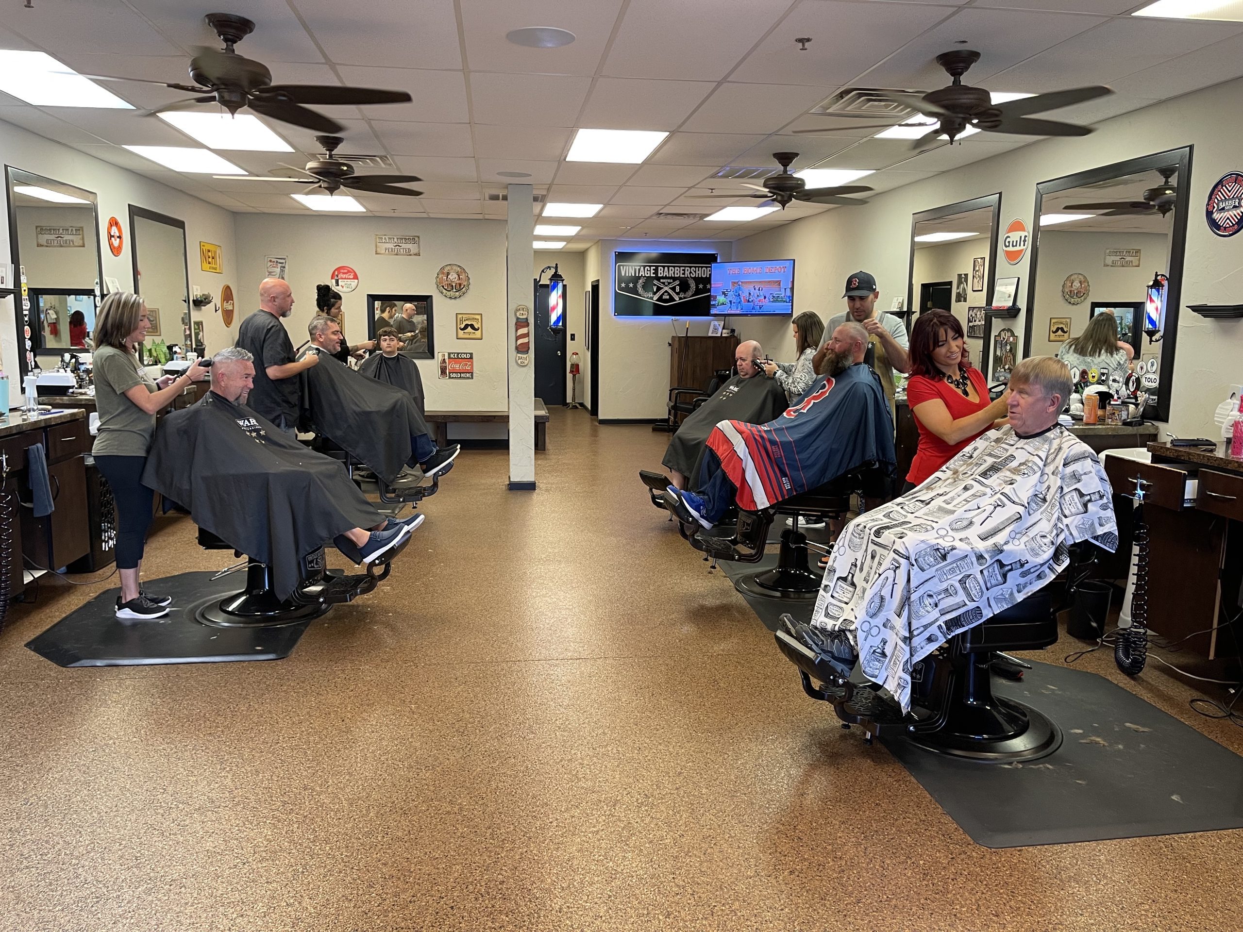 six barbers attending to clients