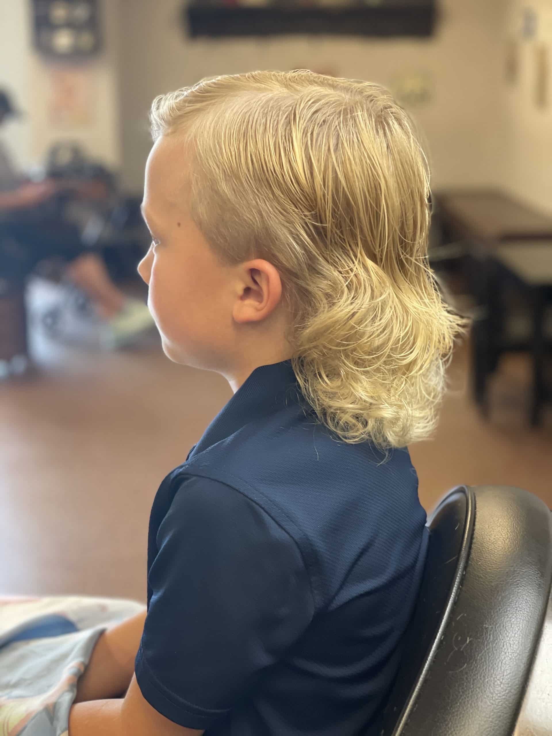 young boy with curly mullet